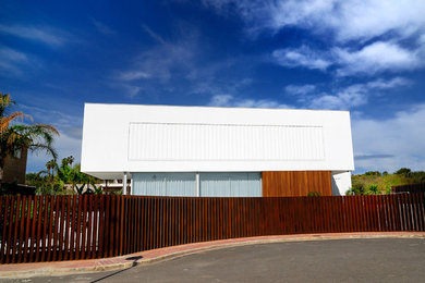 This is an example of a large mediterranean three-storey white house exterior in Valencia with mixed siding, a flat roof and a mixed roof.