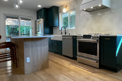 Light wood floor kitchen photo in Seattle with green cabinets, white backsplash and ceramic backsplash