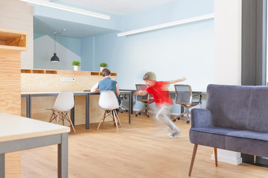 Mittelgroßes Modernes Arbeitszimmer mit Arbeitsplatz, grauer Wandfarbe, braunem Holzboden und Einbau-Schreibtisch in Berlin