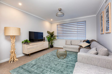 This is an example of a contemporary open concept family room in Perth with a game room, grey walls, carpet, a freestanding tv and beige floor.
