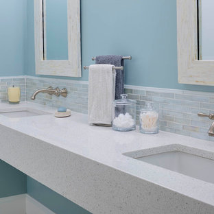 Esempio di una stanza da bagno padronale minimalista di medie dimensioni con lavabo sospeso, top in vetro riciclato e pareti blu