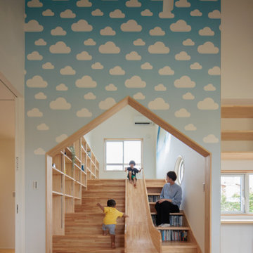 お家の形の入り口には滑り台。雲柄の壁紙を採用し、見ているだけでワクワクするお子様が喜ぶ空間。 階段は登ったり、本を置いたりと用途満載に。