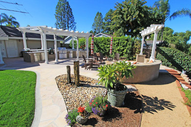 Example of a large backyard concrete paver patio design in Los Angeles with a fire pit and a pergola