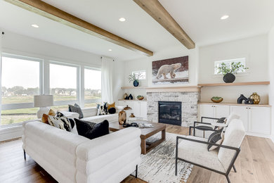 Inspiration for a large modern formal and open concept medium tone wood floor, brown floor and exposed beam living room remodel in Minneapolis with white walls, a standard fireplace, a stone fireplace and a wall-mounted tv