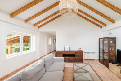 Imagen de salón abierto y blanco y madera rural grande con paredes blancas, suelo de baldosas de terracota, suelo marrón y vigas vistas