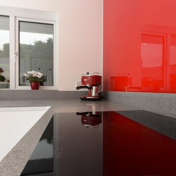 Modern white kitchen with accent red splashback