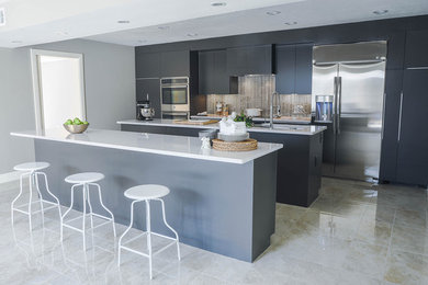 Kitchen - large contemporary single-wall ceramic tile kitchen idea in Houston with an undermount sink, flat-panel cabinets, gray cabinets, quartz countertops, gray backsplash, glass tile backsplash, stainless steel appliances and two islands