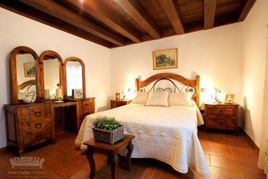 他の地域にある広いラスティックスタイルのおしゃれな客用寝室 (白い壁、セラミックタイルの床、茶色い床)