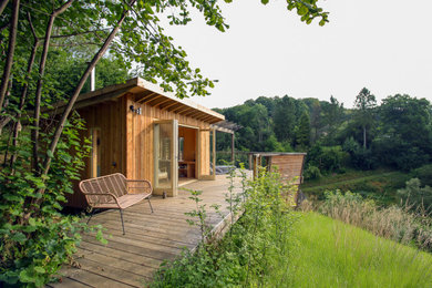 Photo of a medium sized rustic side private and ground level wood railing terrace in Gloucestershire with a roof extension.