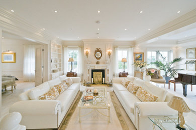 Example of a large classic formal and open concept porcelain tile and beige floor living room design in Dublin with white walls, a standard fireplace, no tv and a wood fireplace surround
