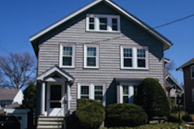 Large and yellow classic two floor house exterior in Boston with vinyl cladding.