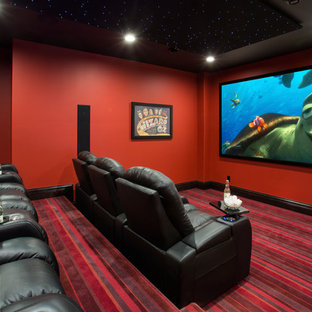 Inspiration pour une salle de cinéma traditionnelle avec un mur rouge, moquette, un écran de projection et un sol multicolore.