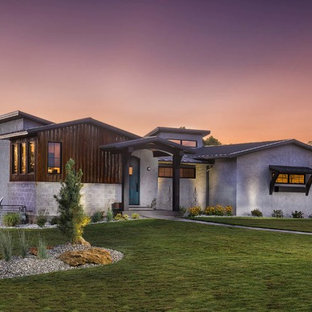 Foto på ett mellanstort industriellt vitt hus, med allt i ett plan, stuckatur och sadeltak