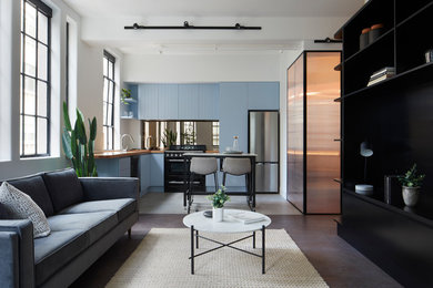 Mid-sized contemporary l-shaped eat-in kitchen in Melbourne with a double-bowl sink, flat-panel cabinets, blue cabinets, wood benchtops, metallic splashback, mirror splashback, stainless steel appliances, ceramic floors, with island and grey floor.