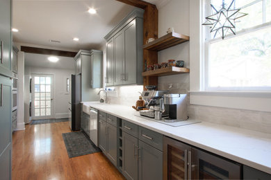 Example of a transitional galley medium tone wood floor enclosed kitchen design in Other with a farmhouse sink, shaker cabinets, green cabinets, quartz countertops, white backsplash, subway tile backsplash, colored appliances, no island and white countertops