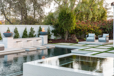 Immagine di una piscina monocorsia contemporanea rettangolare di medie dimensioni e dietro casa con una vasca idromassaggio e pavimentazioni in cemento
