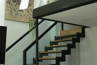This is an example of a medium sized modern mezzanine games room in Cambridgeshire with a reading nook, white walls, a freestanding tv and white floors.