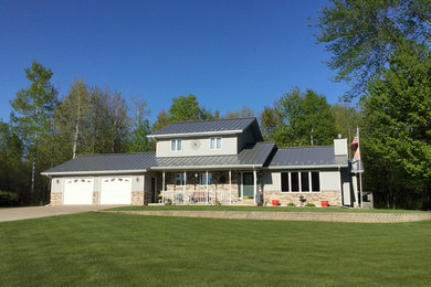 Example of a mid-sized 1950s gray two-story mixed siding exterior home design in Other with a shed roof