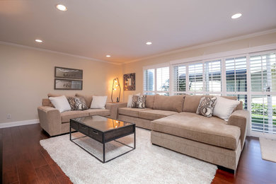 Living room - huge modern formal and open concept dark wood floor and red floor living room idea in Los Angeles with beige walls and a wall-mounted tv