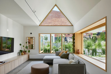 Design ideas for a large contemporary open concept living room in Melbourne with white walls, concrete floors, a wall-mounted tv and grey floor.