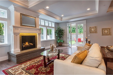 Photo of a classic formal open plan living room with grey walls, dark hardwood flooring, a standard fireplace, a tiled fireplace surround and no tv.