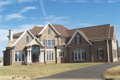 Example of a beige two-story stone exterior home design in Other
