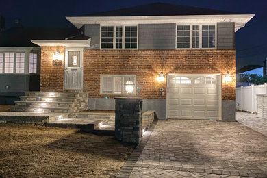 Large trendy concrete paver porch photo in New York