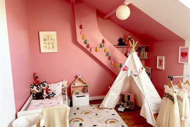 Cette photo montre une chambre d'enfant de 4 à 10 ans tendance de taille moyenne avec un mur rose, parquet clair et un sol beige.
