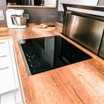 Cuisine blanc mat et noir fenix avec hotte intégrée dans un plan de travail