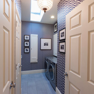 デンバーの大きいコンテンポラリースタイルのおしゃれな洗濯室 (フラットパネル扉のキャビネット、白いキャビネット、磁器タイルの床、左右配置の洗濯機・乾燥機、グレーの床) の写真