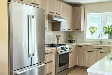 Mid-sized trendy u-shaped eat-in kitchen photo in Chicago with a single-bowl sink, flat-panel cabinets, light wood cabinets, quartz countertops, beige backsplash, ceramic backsplash, stainless steel appliances, a peninsula and beige countertops