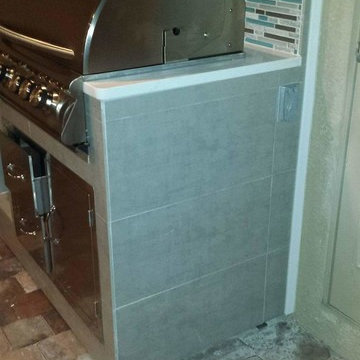 Outdoor Kitchen with Gray Tile Exterior, L bar and Quartz Tops