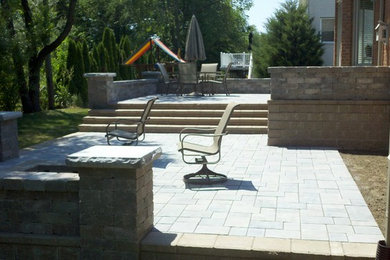 Inspiration for a transitional backyard brick patio remodel in Detroit with a fire pit
