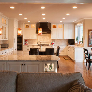 Mid-sized traditional kitchen pantry designs - Kitchen pantry - mid-sized traditional u-shaped medium tone wood floor kitchen pantry idea in Raleigh with an undermount sink, raised-panel cabinets, white cabinets, granite countertops, beige backsplash, subway tile backsplash, stainless steel appliances and an island