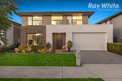 Large modern two-storey beige exterior in Melbourne with mixed siding and a gable roof.