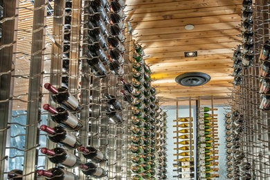 Design ideas for a large modern wine cellar in Dallas with display racks and light hardwood floors.