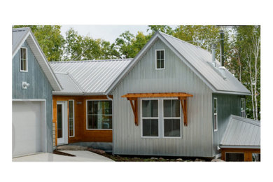 Example of a large minimalist gray three-story gable roof design in Other