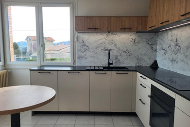 Réalisation d'une cuisine tradition en L fermée avec un plan de travail en granite, aucun îlot et plan de travail noir.