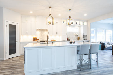 Example of a large transitional l-shaped vinyl floor and gray floor open concept kitchen design in Other with an undermount sink, shaker cabinets, white cabinets, quartz countertops, white backsplash, marble backsplash, stainless steel appliances, an island and white countertops