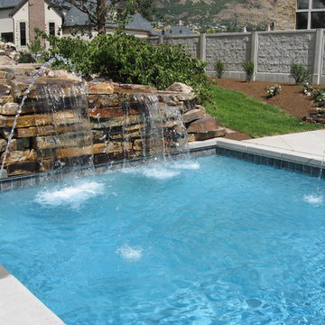 Rock water feature flowing into swimming pool