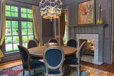 Inspiration for a large timeless medium tone wood floor enclosed dining room remodel in Other with gray walls, a two-sided fireplace and a stone fireplace