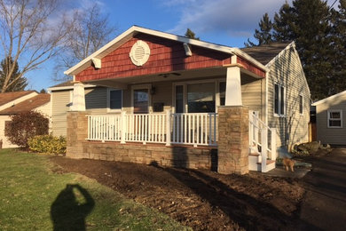 Example of a mid-sized arts and crafts beige one-story wood exterior home design in Other