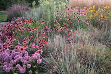 Imagen de jardín de secano ecléctico extra grande en verano en patio trasero con parterre de flores, exposición total al sol y adoquines de piedra natural