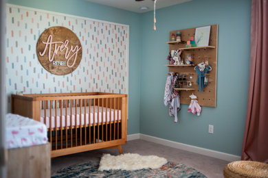 Diseño de habitación de bebé niña de tamaño medio con paredes azules, moqueta y suelo beige