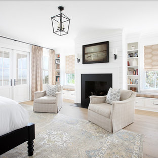 Klassisches Gästezimmer mit weißer Wandfarbe, hellem Holzboden, Kamin und beigem Boden in Charleston