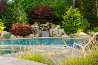 This is an example of a mid-sized full sun backyard concrete paver landscaping in Boston.