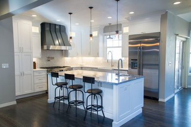 Eat-in kitchen - mid-sized transitional l-shaped dark wood floor and brown floor eat-in kitchen idea in Denver with a farmhouse sink, shaker cabinets, white cabinets, quartz countertops, white backsplash, porcelain backsplash, stainless steel appliances and an island