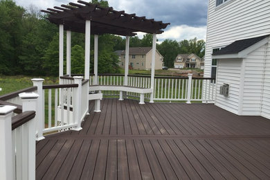 Photo of a mid-sized traditional backyard deck in New York with a pergola.