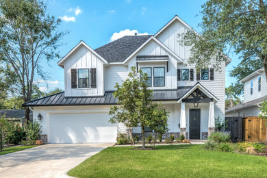 Large cottage white two-story concrete fiberboard exterior home idea in Houston with a mixed material roof