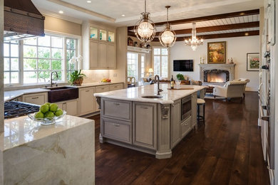 Inspiration for a large timeless u-shaped dark wood floor and brown floor open concept kitchen remodel in San Diego with a farmhouse sink, recessed-panel cabinets, white cabinets, marble countertops, stainless steel appliances and an island